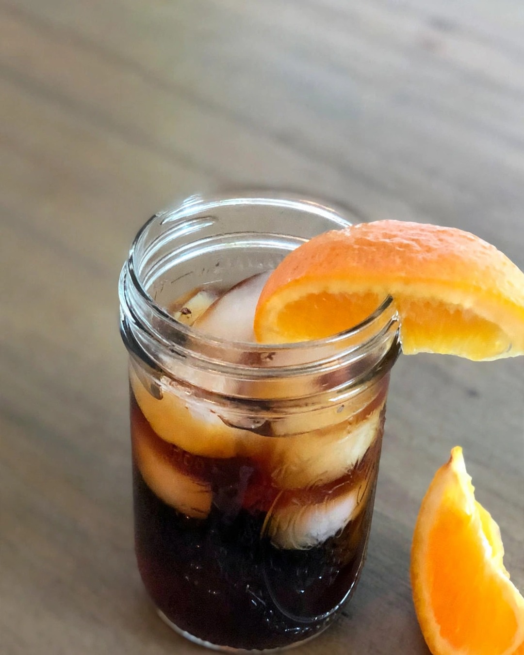 Ly cold brew đá cạnh túi cà phê ANARO trên bàn gỗ, ánh sáng tự nhiên